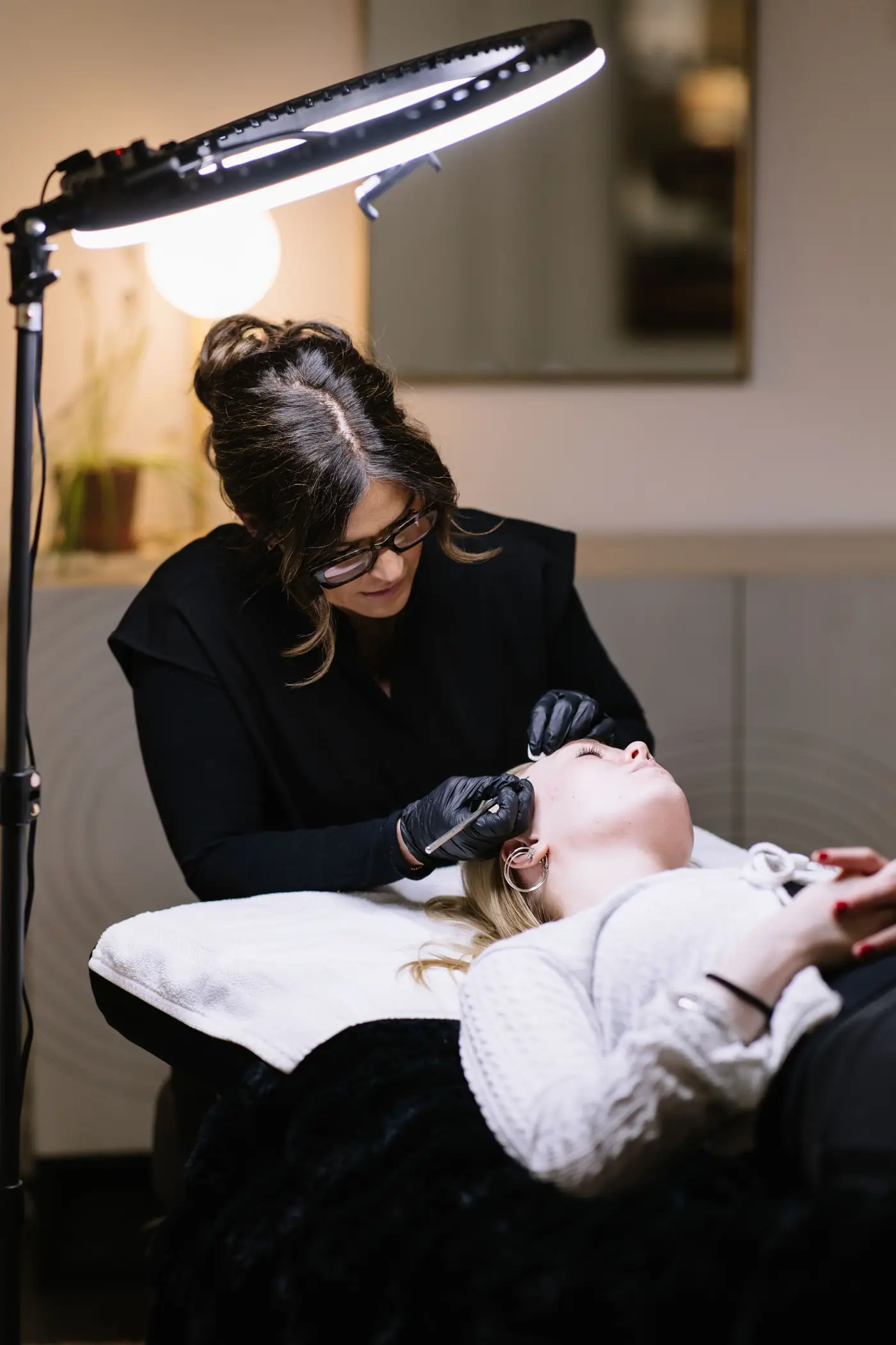 Esthéticienne qui soigne les sourcils d’une cliente