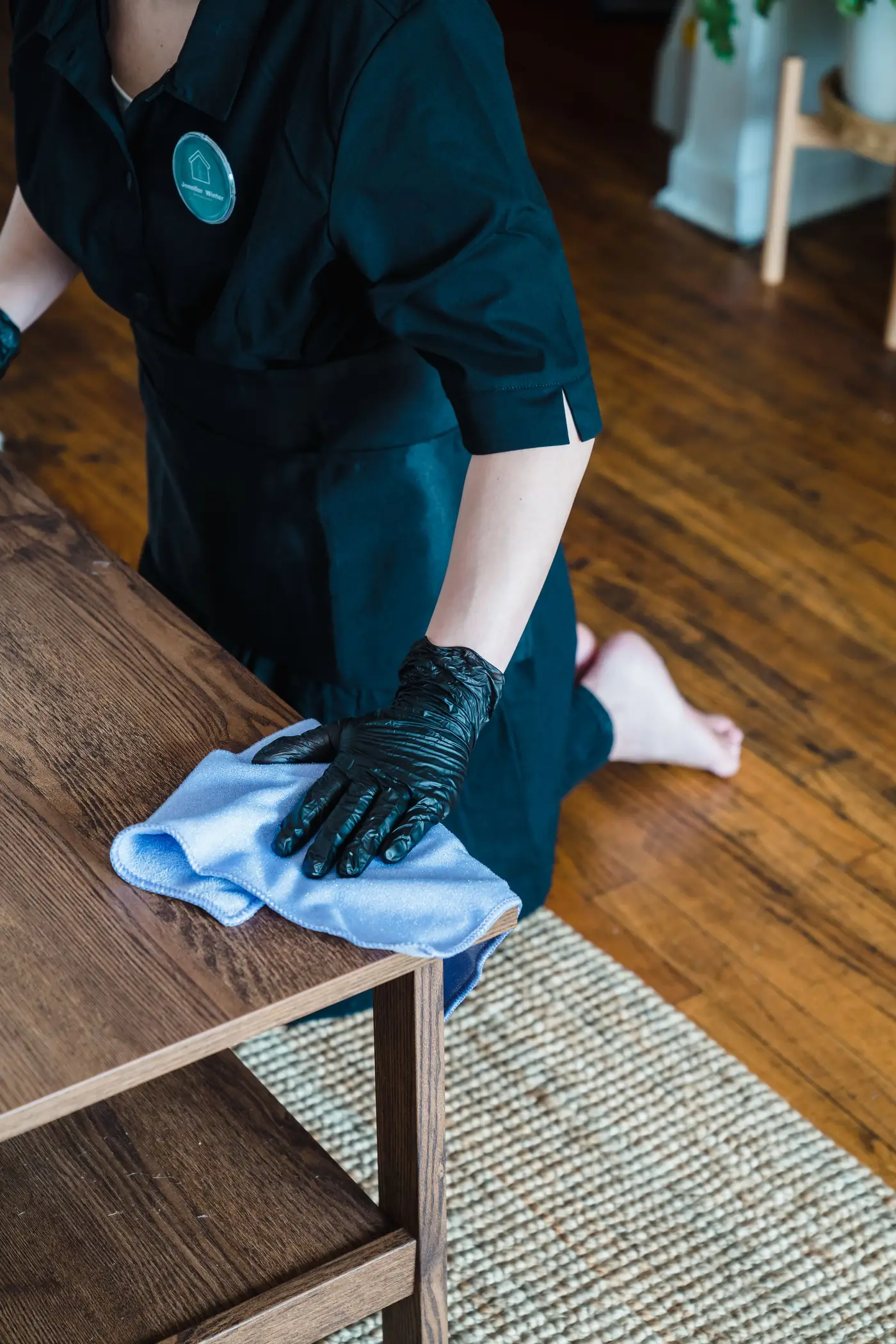 Main gantée qui nettoie une table