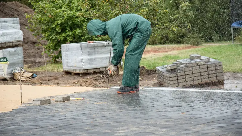 Tuinaannemer legt betonklinkers voor een oprit