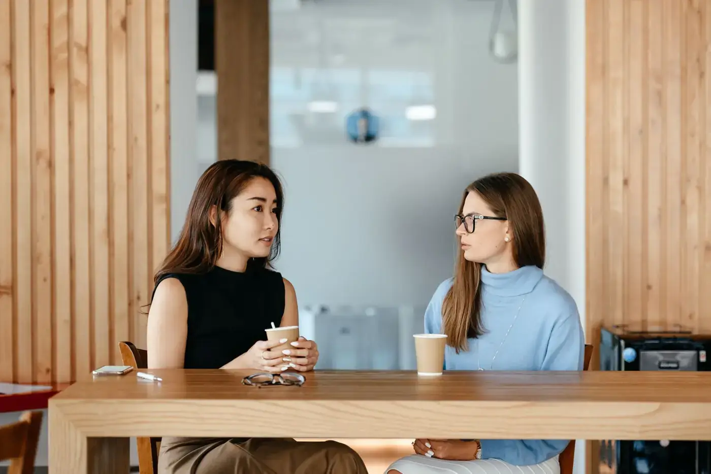 Coachgesprek aan een houten tafel
