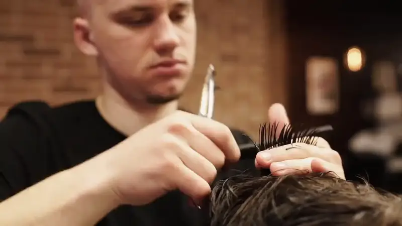Friseur schneidet Haare mit Schere und Kamm
