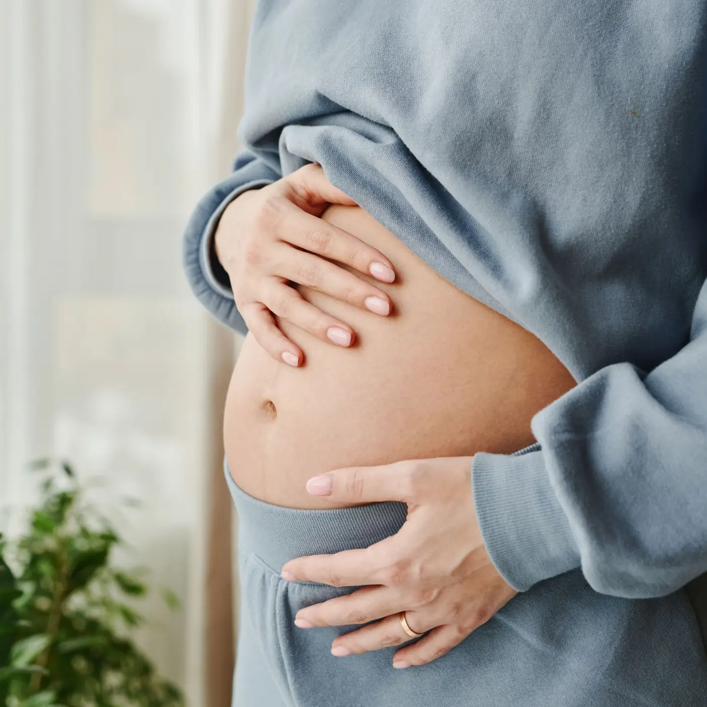 Schwangere Frau hält ihre Hände an den Bauch