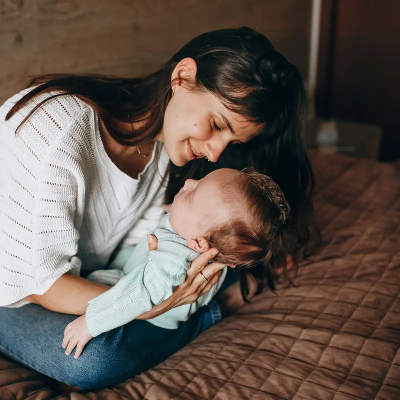 Mutter spielt mit ihrem Baby auf dem Bett