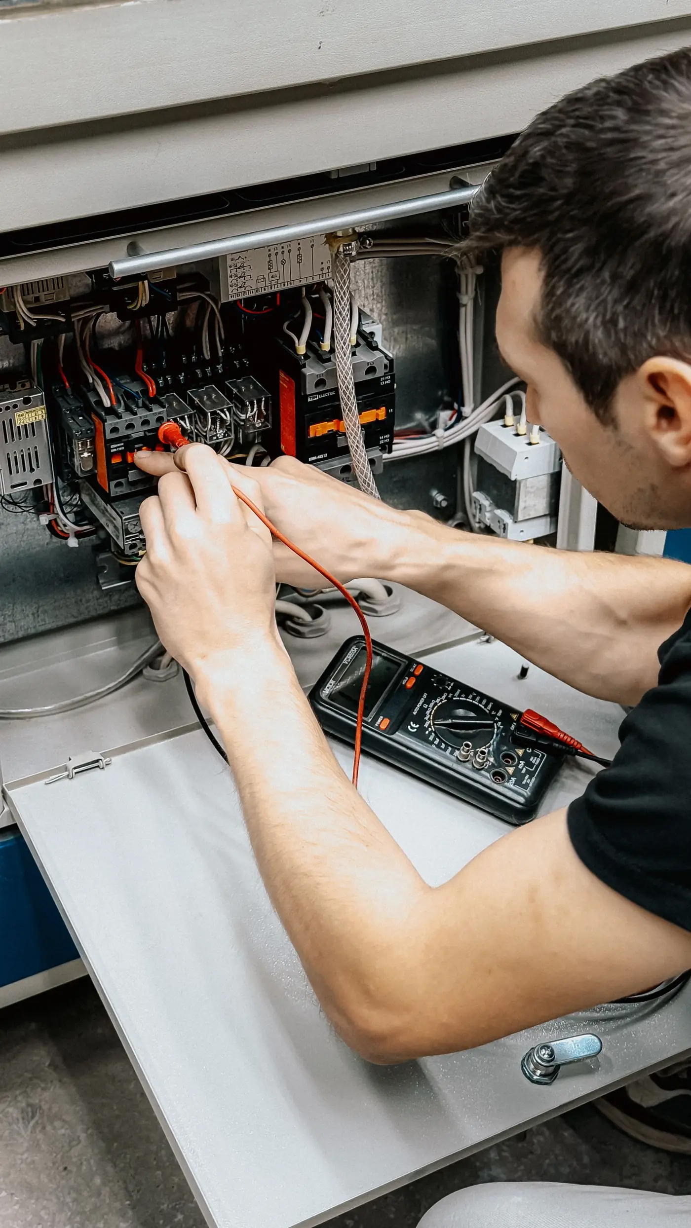 Elektricien meet met een multimeter in een kast