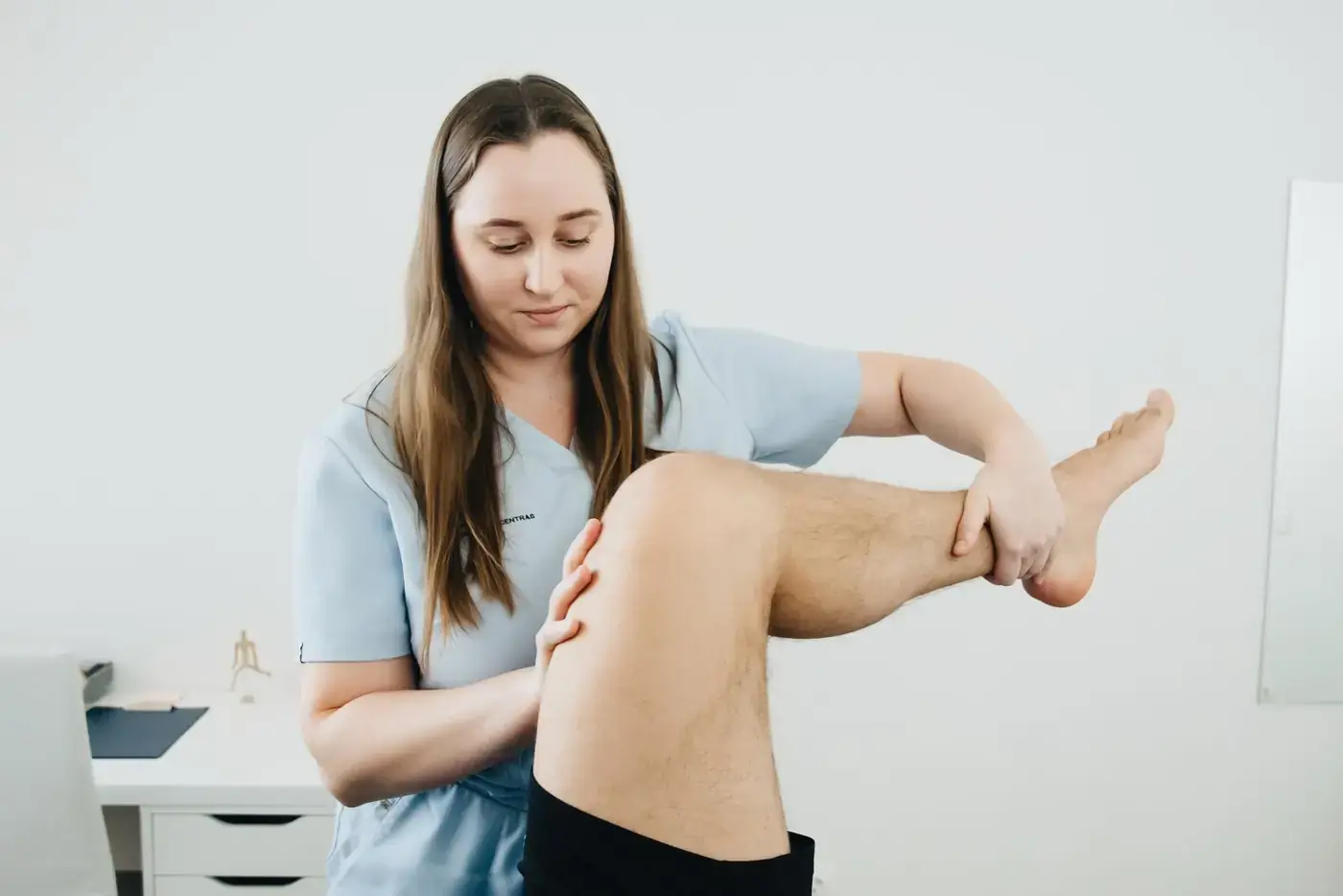Fysiotherapeut onderzoekt een knie