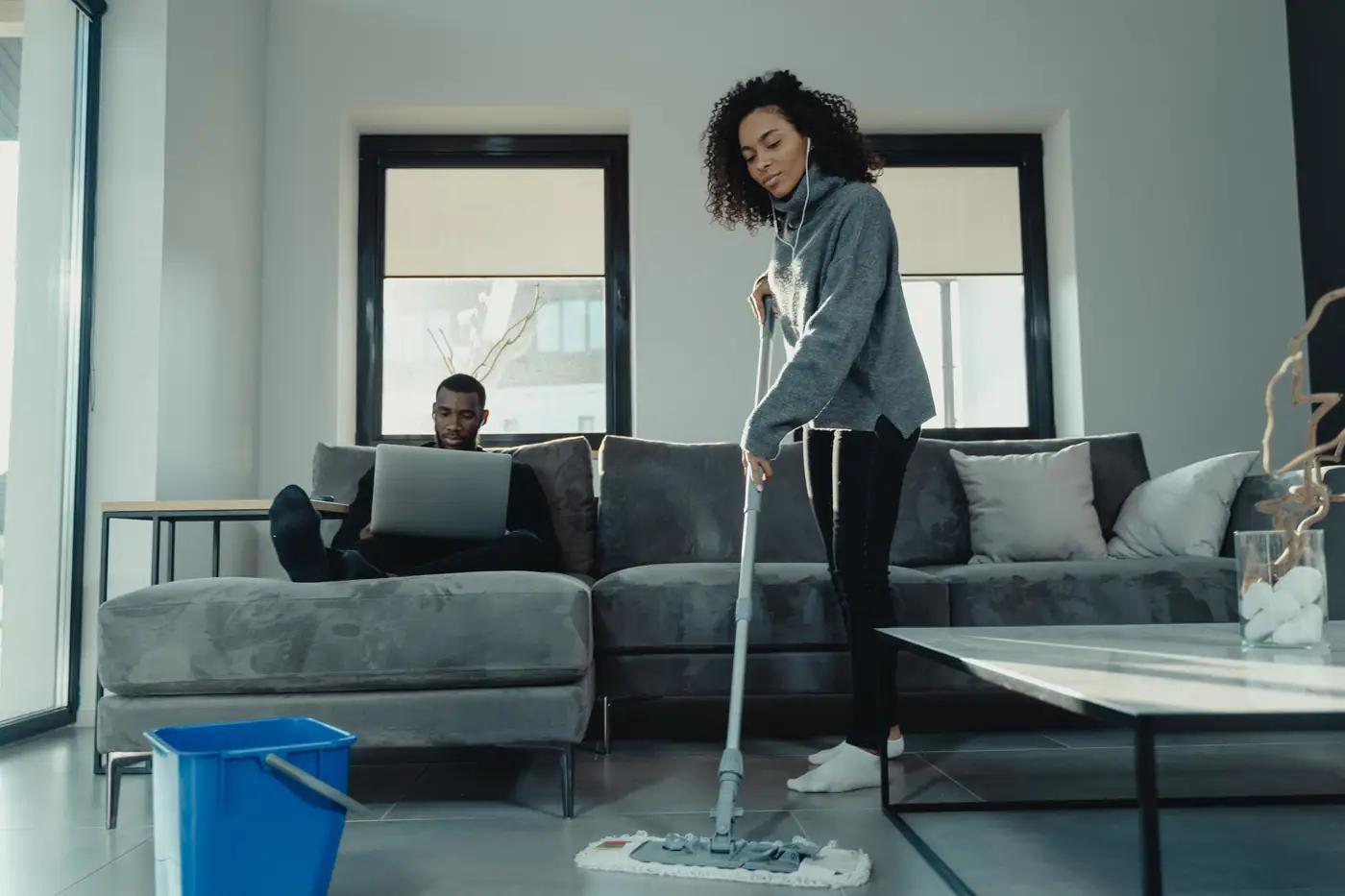 Woman mopping a living room floor