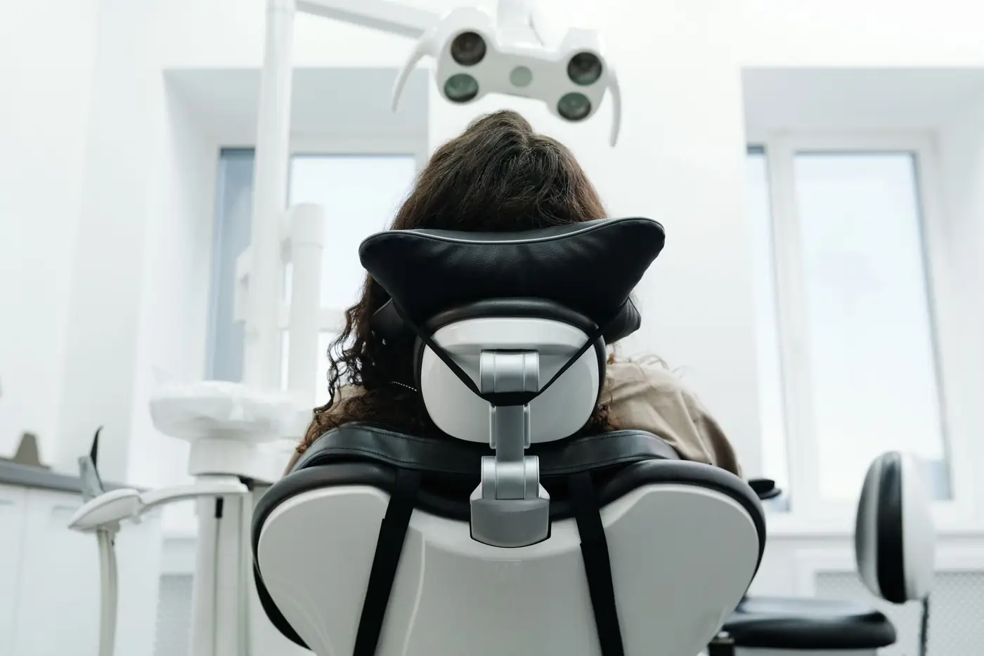 Patient sitting back in a dental chair under the lamp