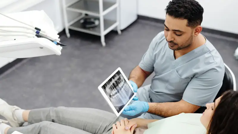 Dentist talking a patient through a scan on a tablet