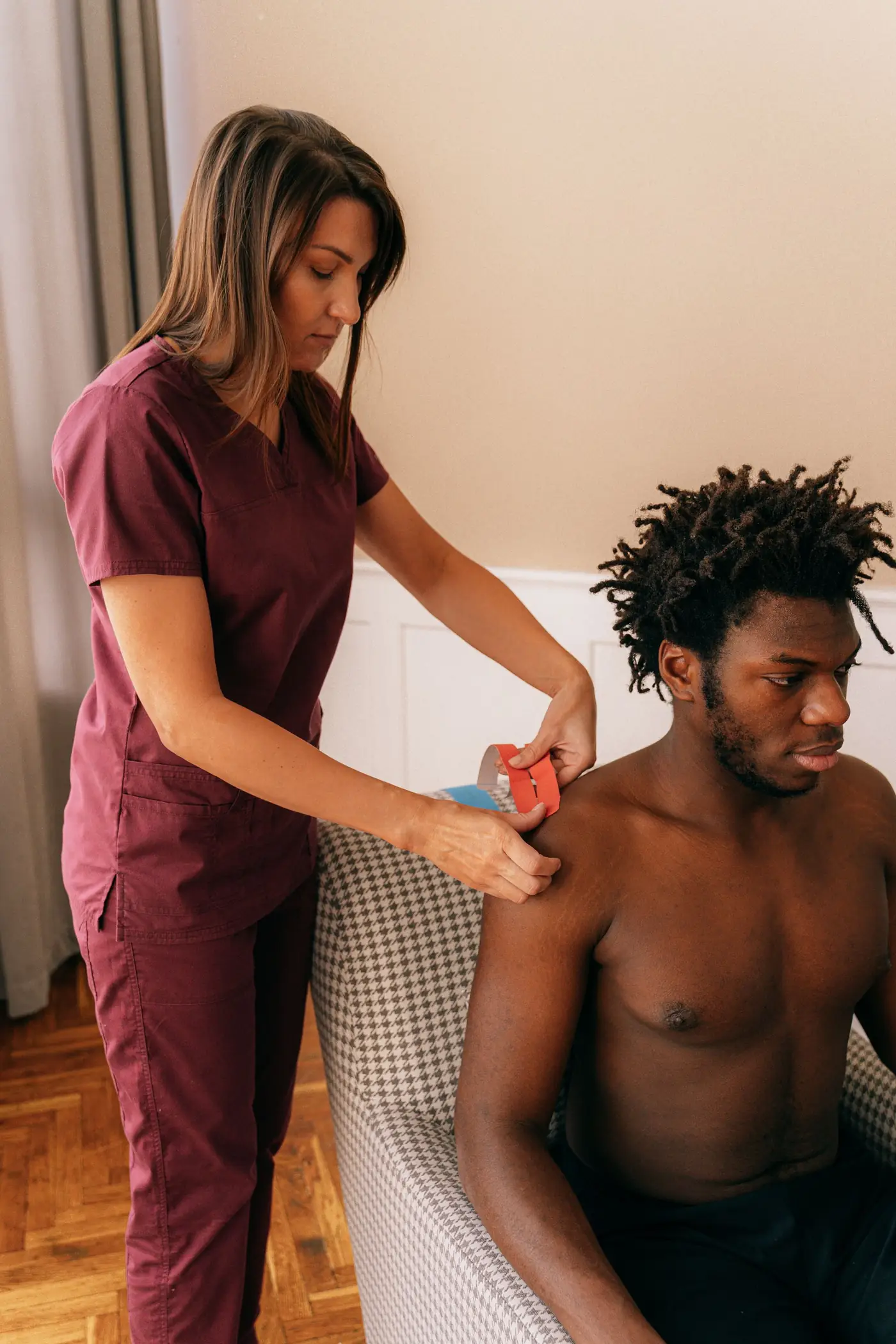 Physio assessing a man’s shoulder