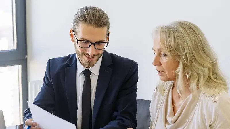 Solicitor and client going through papers at a desk