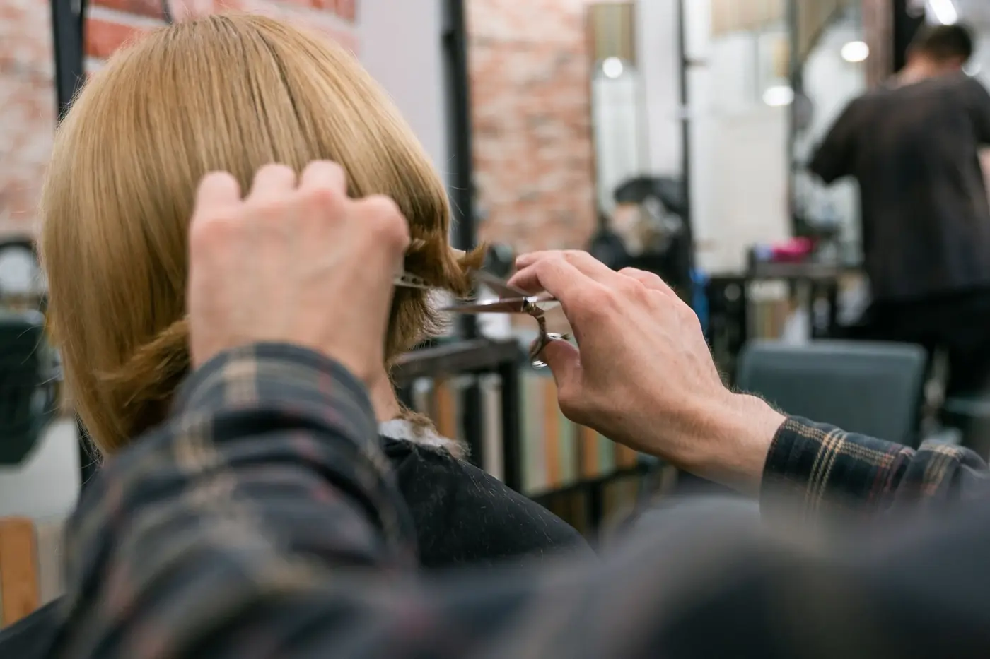 Kapper knipt blond haar in de salon