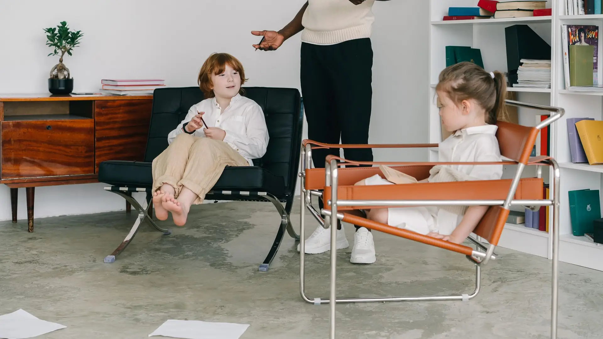 Logopedist werkt met twee kinderen in een lichte ruimte