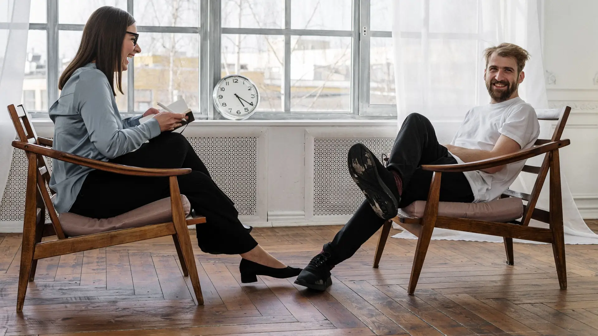 Twee mensen in gesprek in een rustige praktijkruimte