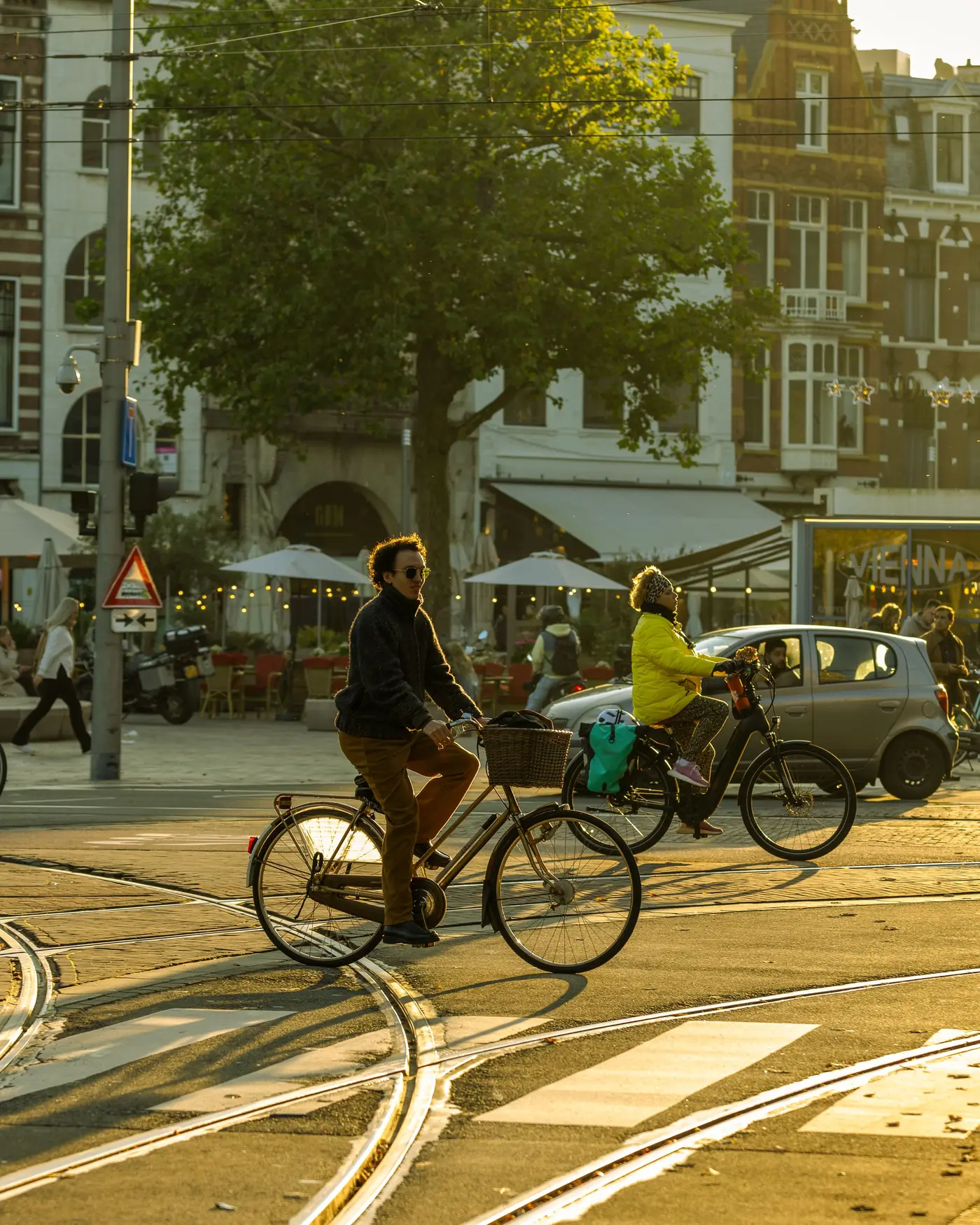 Fietsers in een drukke straat bij zonsondergang