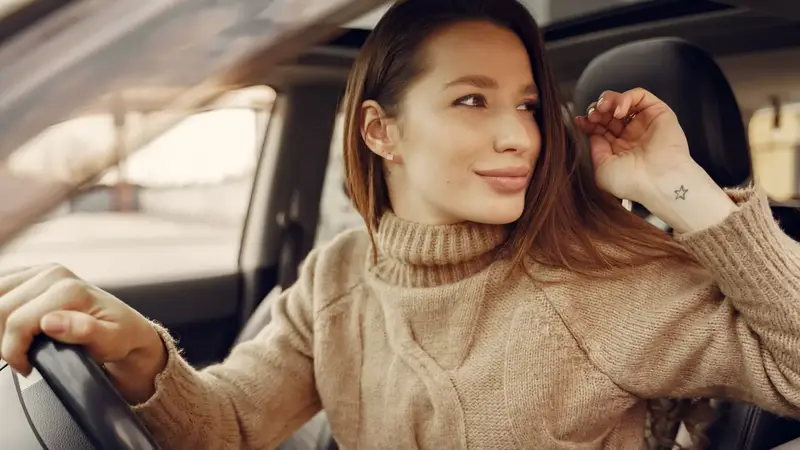 Jonge vrouw achter het stuur, klaar om te rijden