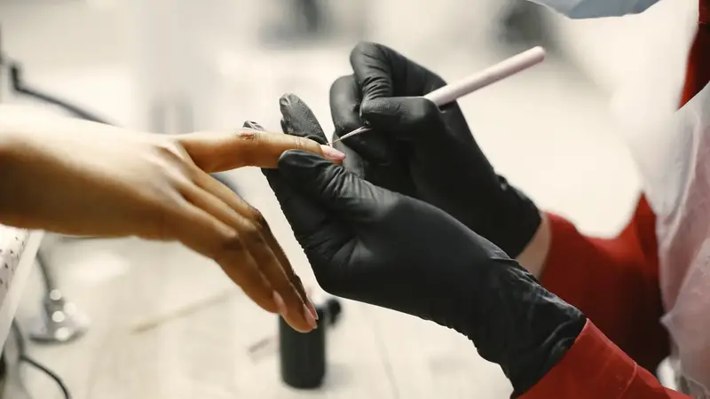 Manicure met zwarte handschoenen en vijl