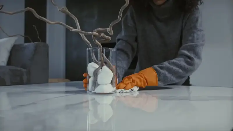 Schoonmaker neemt een tafel af met handschoenen aan