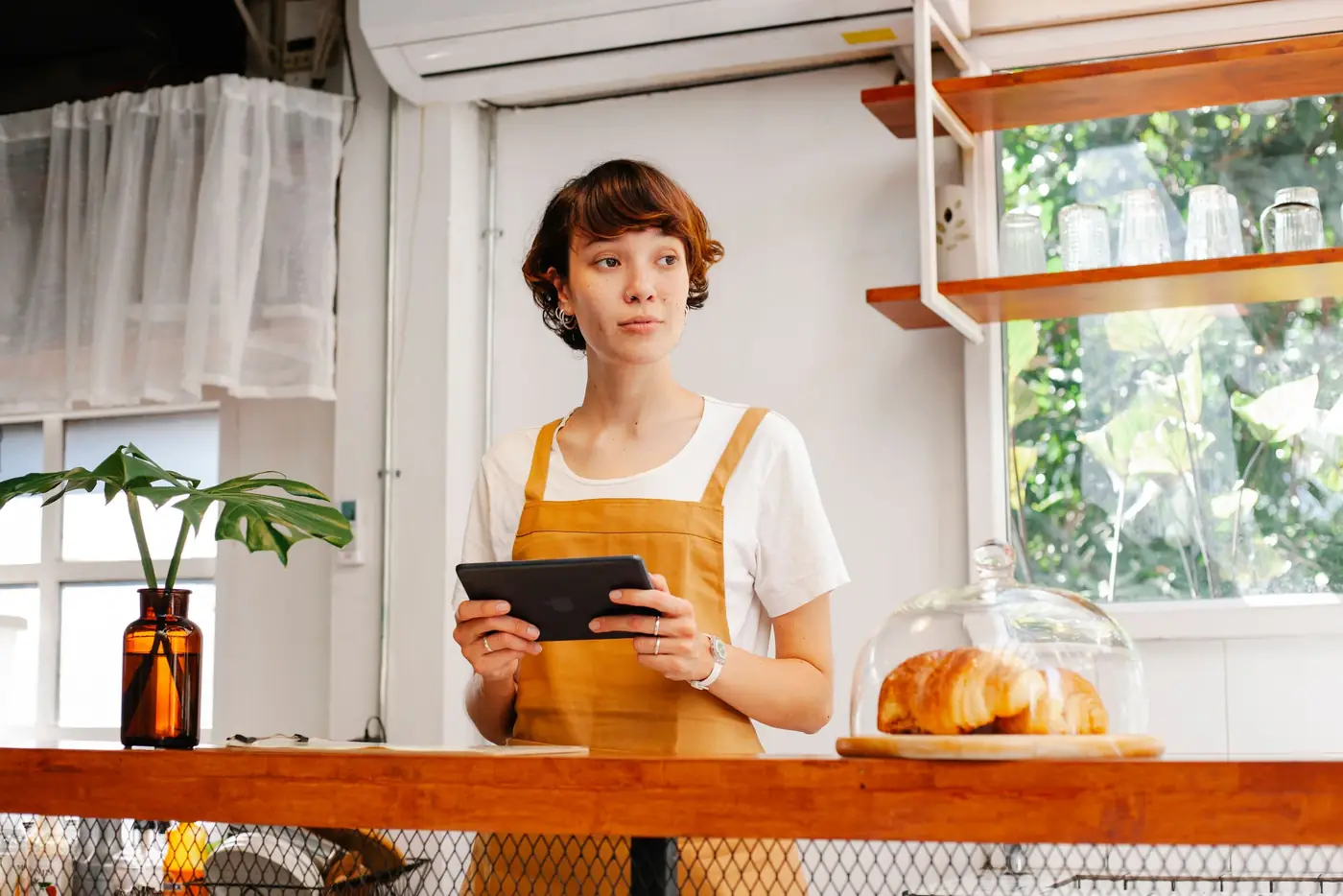 Small business owner checking a tablet in her kitchen
