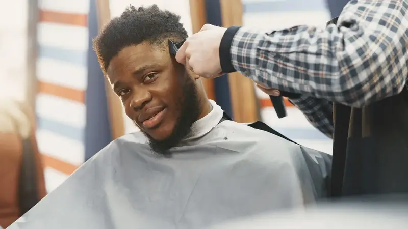 Barber cutting a smiling customer’s hair
