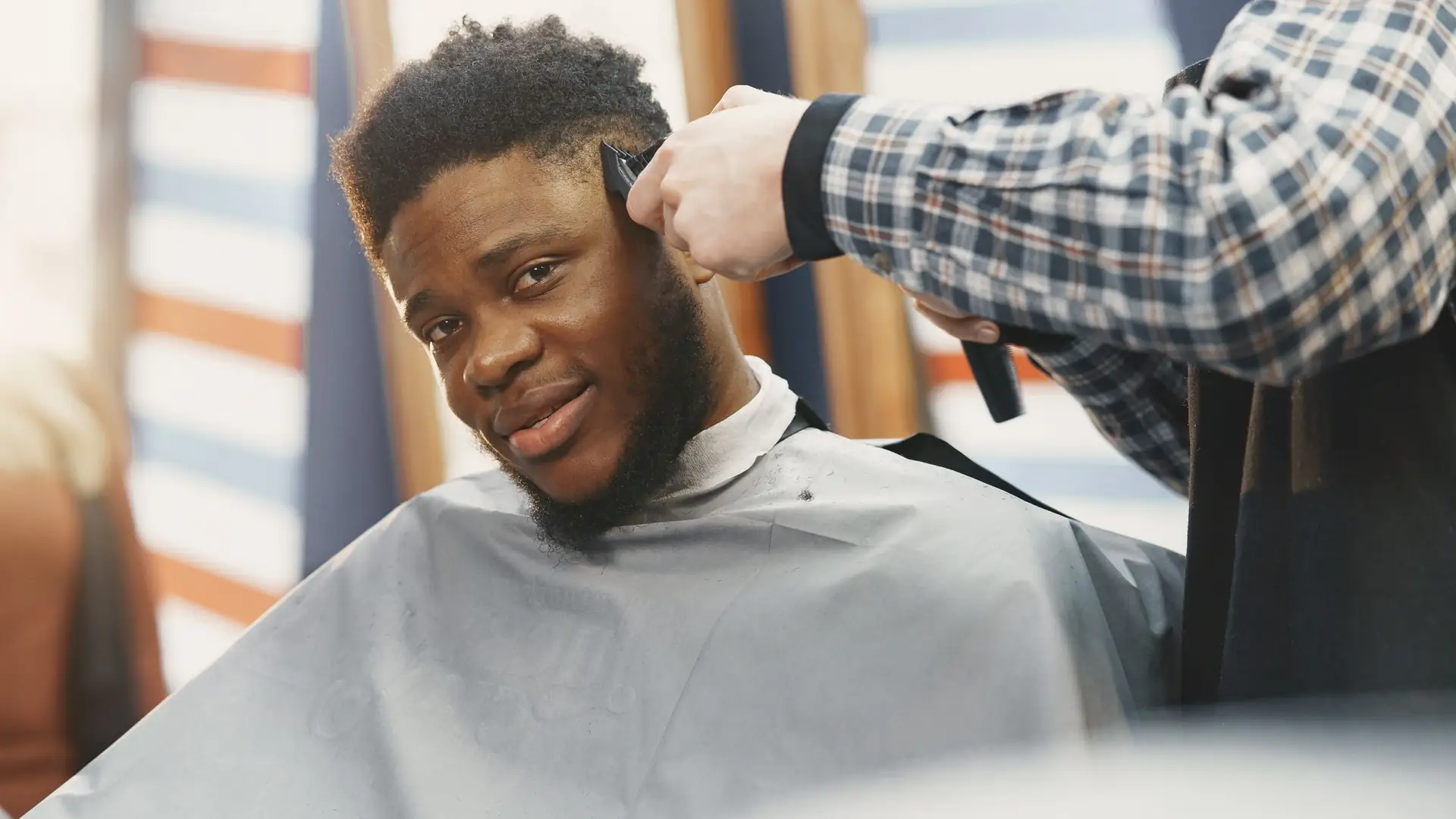 Barber cutting a smiling customer’s hair