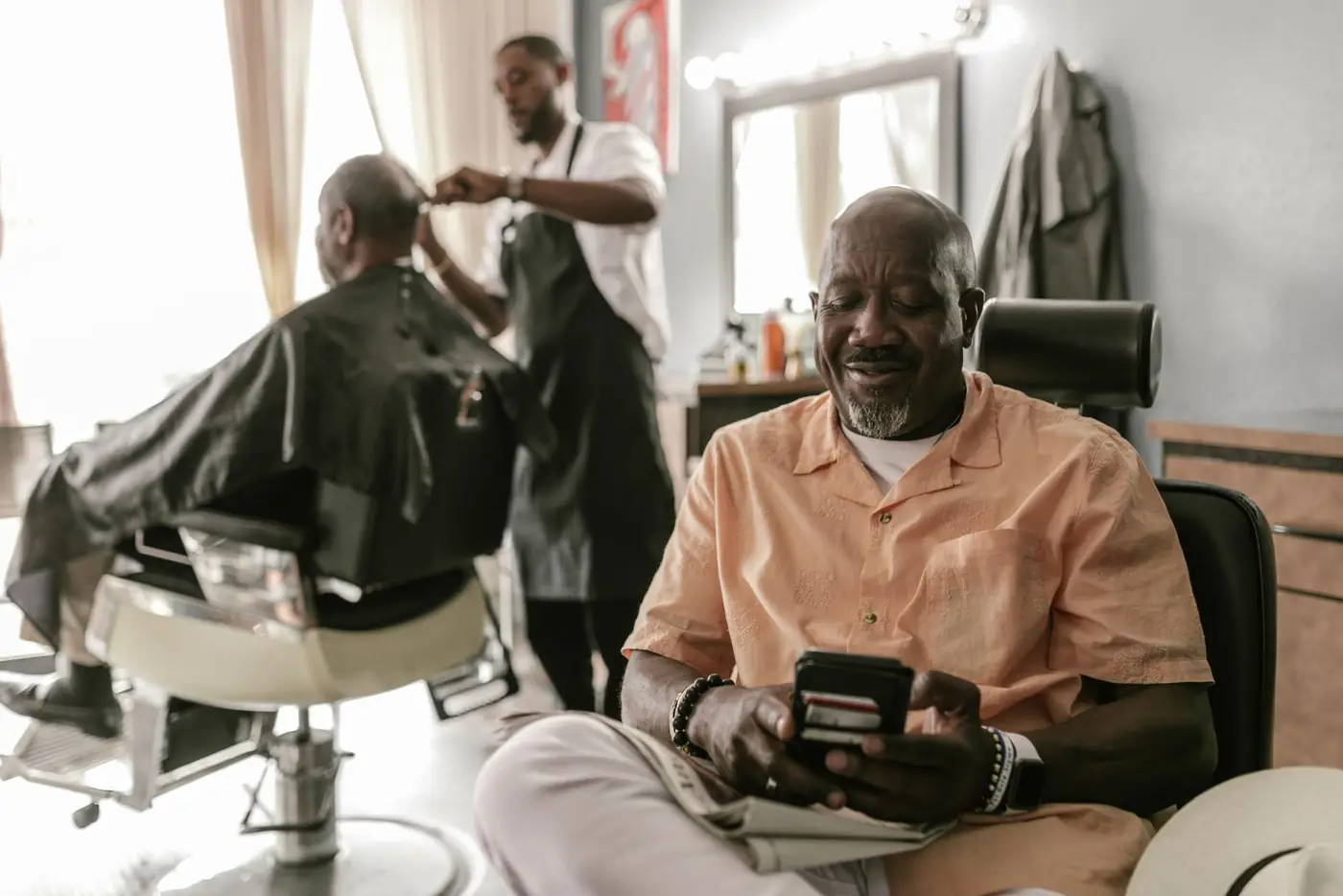 Customers in barber chairs chatting