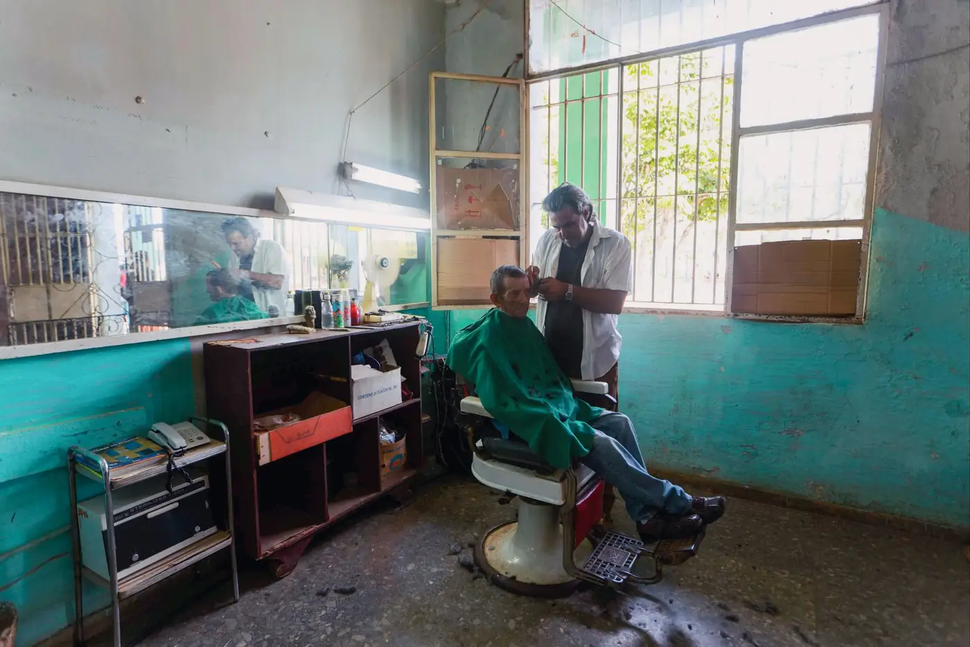 Barber at work in a small traditional shop