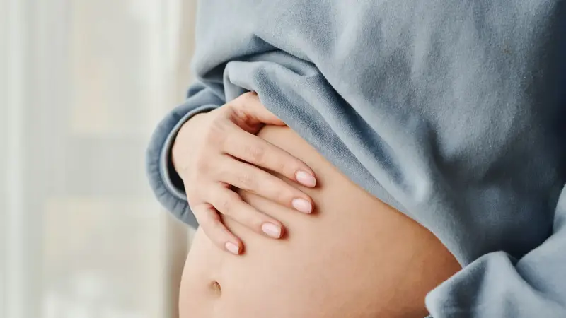 Zwangere vrouw met haar handen op haar buik
